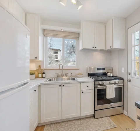 a kitchen with a stove sink and cabinets