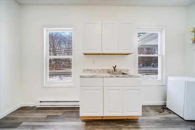 a kitchen with a sink and wooden floor