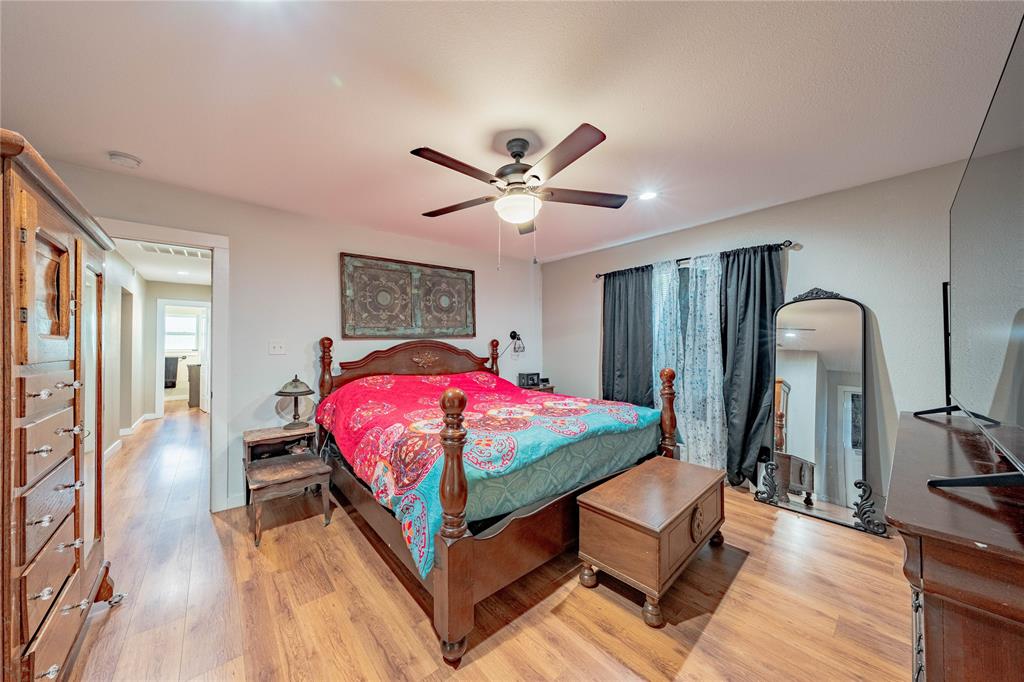 603 Mosley Road Athens, TX 75751 - Photo 12 of 14 a bedroom with a bed and a chandelier