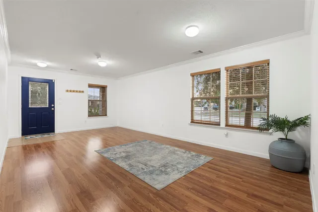 a view of hallway with wooden floor and a floor to ceiling window