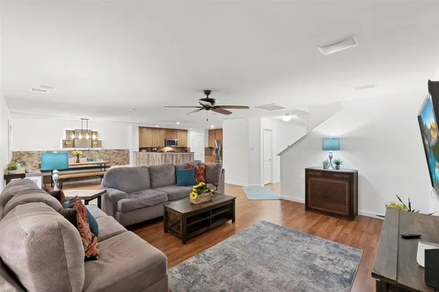 a living room with furniture and a wooden floor