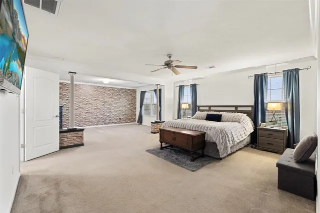 a spacious bedroom with a bed and a chandelier