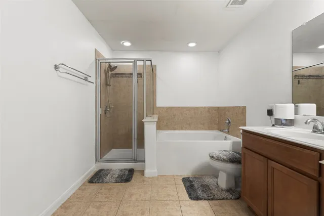 a bathroom with a bathtub shower sink mirror and toilet