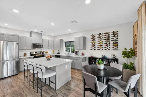 a kitchen with a dining table chairs and refrigerator