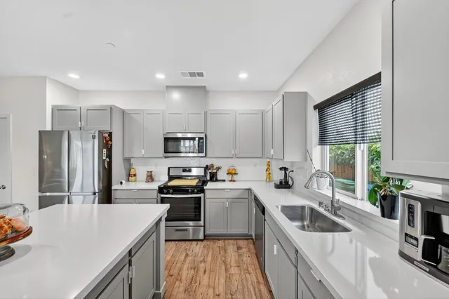 a kitchen with a sink a stove a refrigerator cabinets a sink and a counter top space