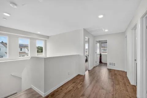 a view of a kitchen with wooden floor and a window
