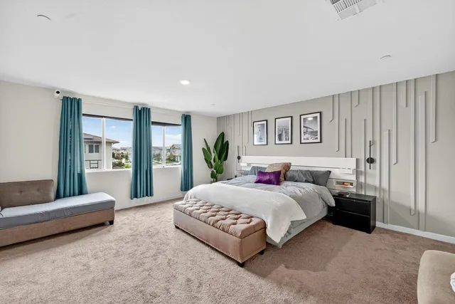 a bedroom with a large bed couch and a window