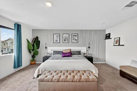 a bedroom with a large bed and a potted plant