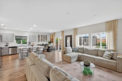 a living room with furniture wooden floor and a large window