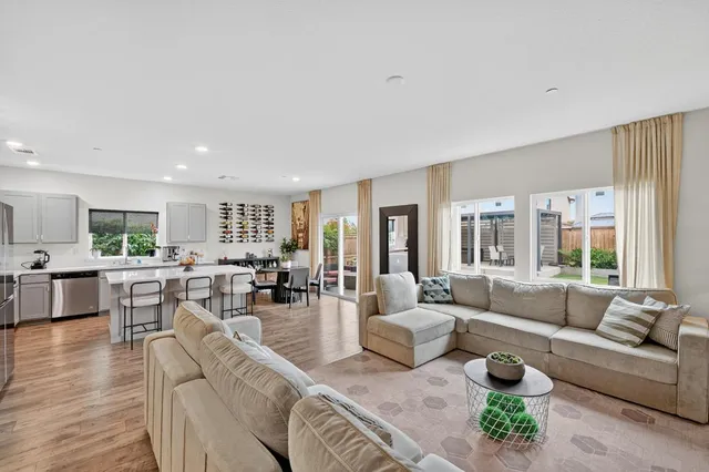 a living room with furniture wooden floor and a large window