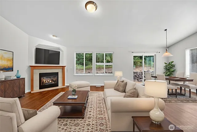 a living room with furniture a fireplace and a large window