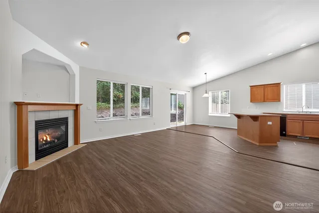 a view of empty room with wooden floor and fireplace
