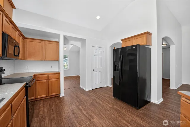 a kitchen with stainless steel appliances granite countertop a refrigerator and a stove top oven