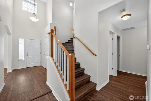 a view of a hallway with wooden floor and staircase
