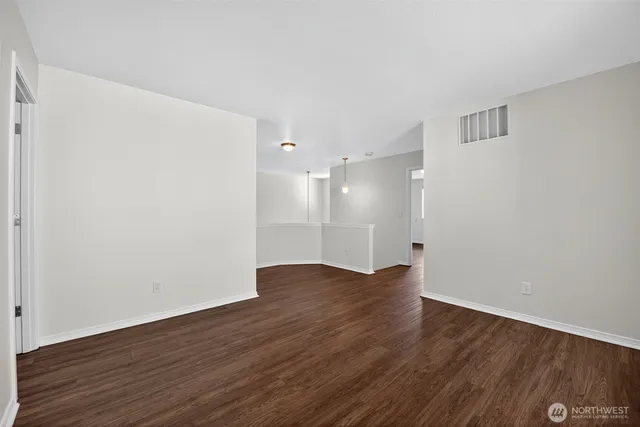 a view of an empty room with wooden floor