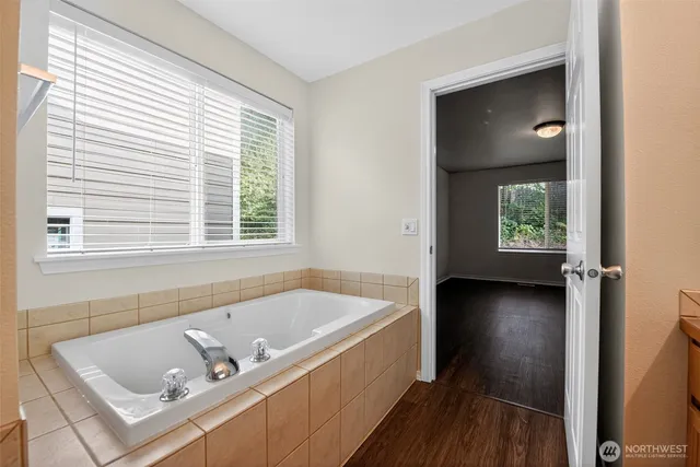 a bathroom with a tub a sink and a window