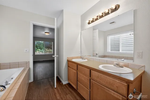 a bathroom with a sink double vanity granite tub and shower