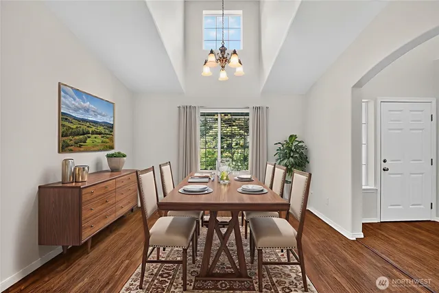 a view of a dining room with furniture a chandelier and wooden floor