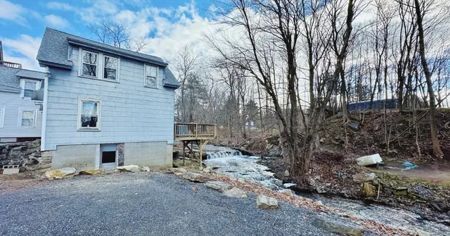a backyard of a house with fire pit and trees