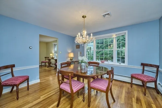 a dining room with furniture a chandelier and wooden floor