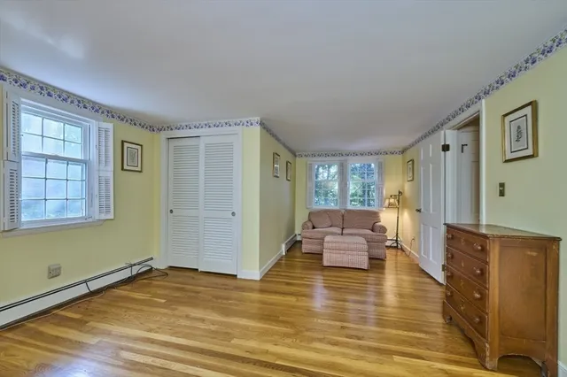 a spacious bedroom with a bed and wooden floor