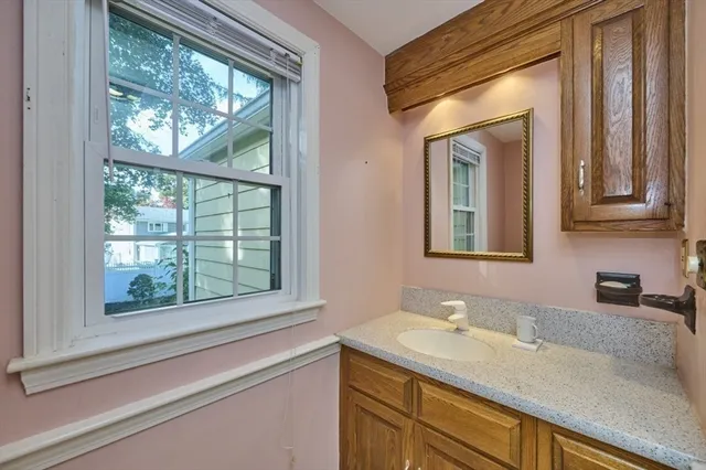 a bathroom with a granite countertop sink and a window