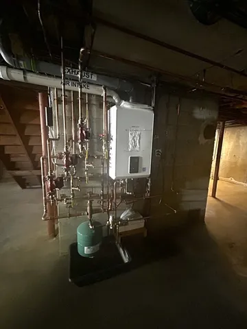 a room with water heater and wooden wall