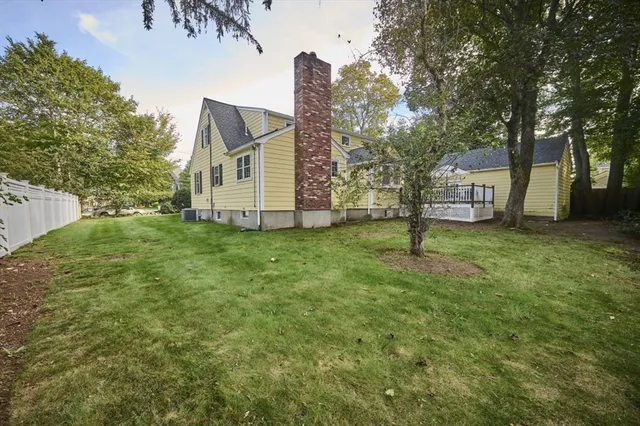 a view of a house with a big yard and large tree