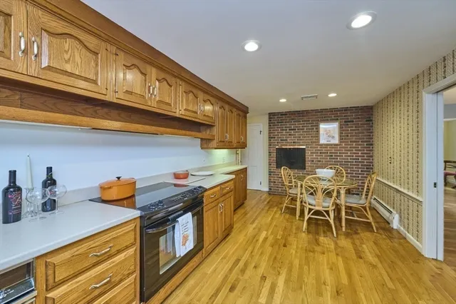 a kitchen with stainless steel appliances granite countertop a stove and a wooden floors