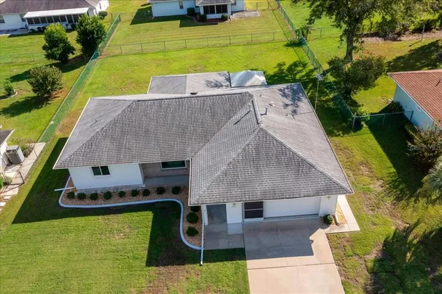 an aerial view of a house with a garden and swimming pool