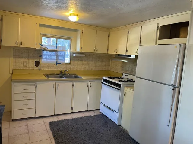 a kitchen with cabinets stainless steel appliances and a window