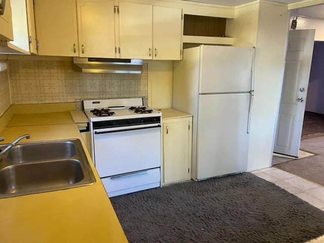 a kitchen with a sink a refrigerator and a stove
