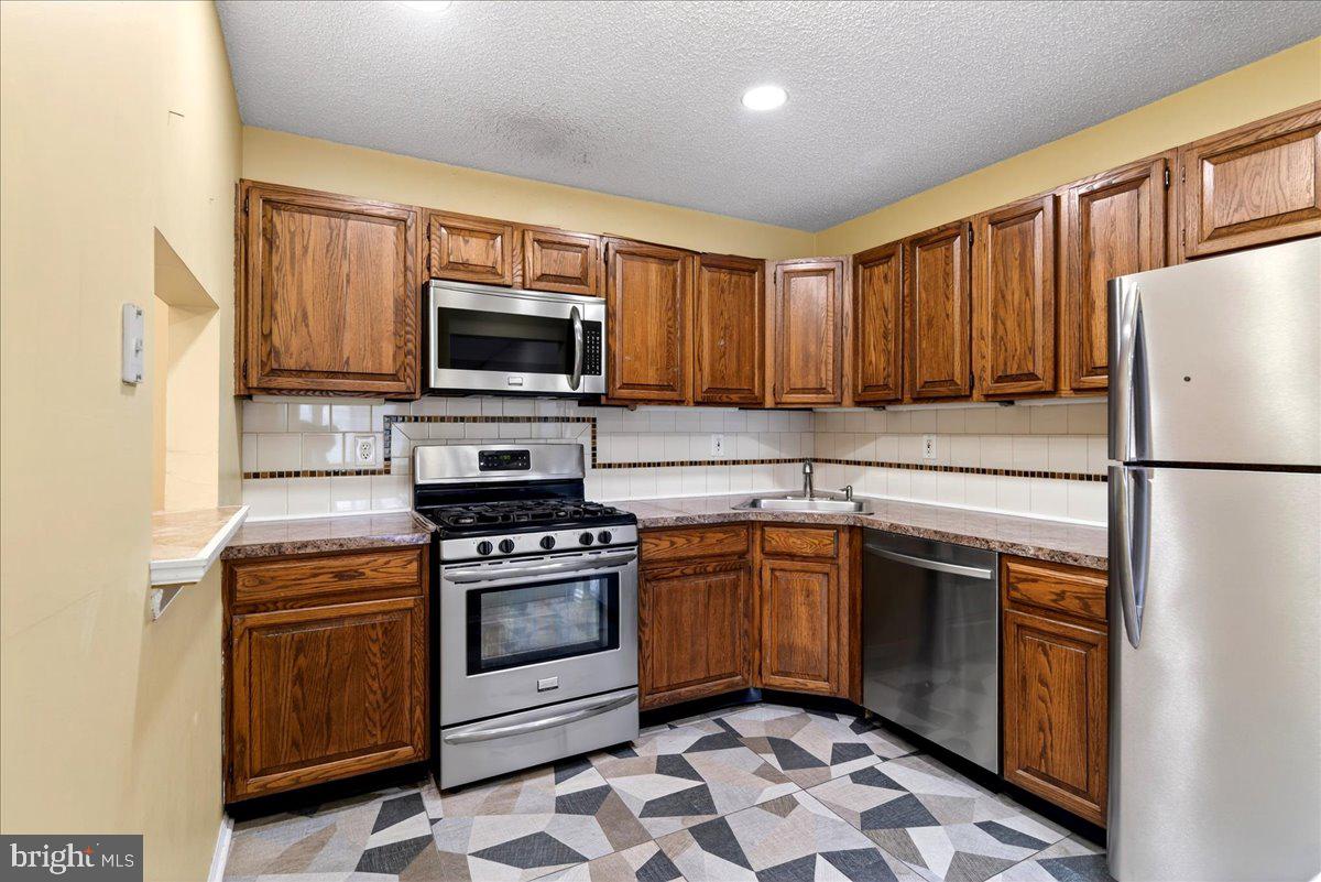28 Holly Court Hamilton, NJ 08619 - Photo 13 of 29 a kitchen with stainless steel appliances granite countertop a stove top oven a sink and a refrigerator