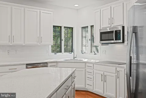 a kitchen with stainless steel appliances white cabinets and a sink