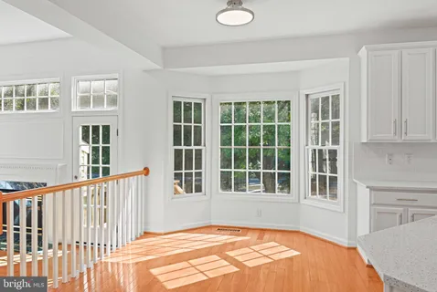 a view of a bedroom with wooden floor and windows