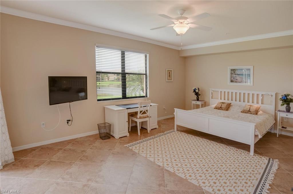 9126 Napoli Court, Unit 101 Naples, FL 34113 - Photo 9 of 32 a bedroom with a bed and a flat screen tv