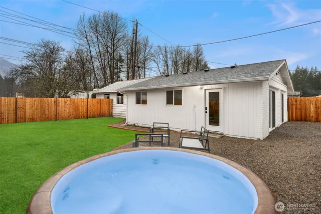 a view of a backyard with table and chairs and wooden fence