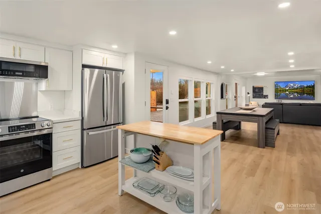 a kitchen with stainless steel appliances granite countertop a refrigerator sink and a stove