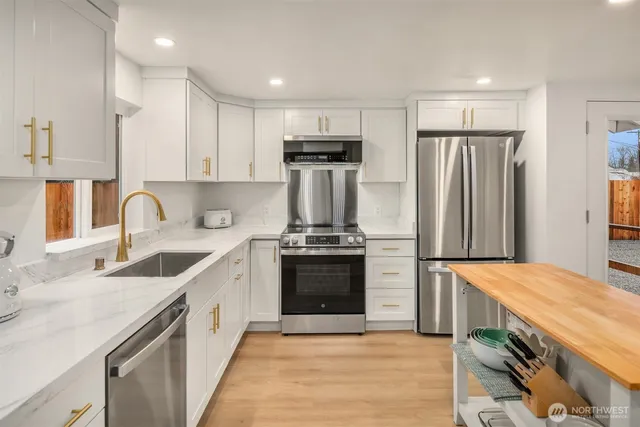 a kitchen with stainless steel appliances granite countertop a sink stove and refrigerator