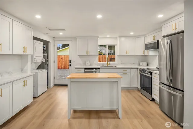 a kitchen with stainless steel appliances a sink stove refrigerator and cabinets