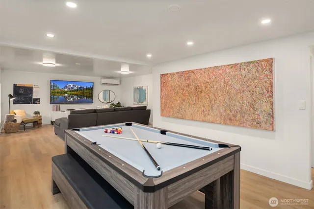 a living room with stainless steel appliances furniture and flat screen tv
