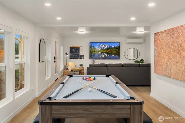 a living room with furniture pool table and a large window