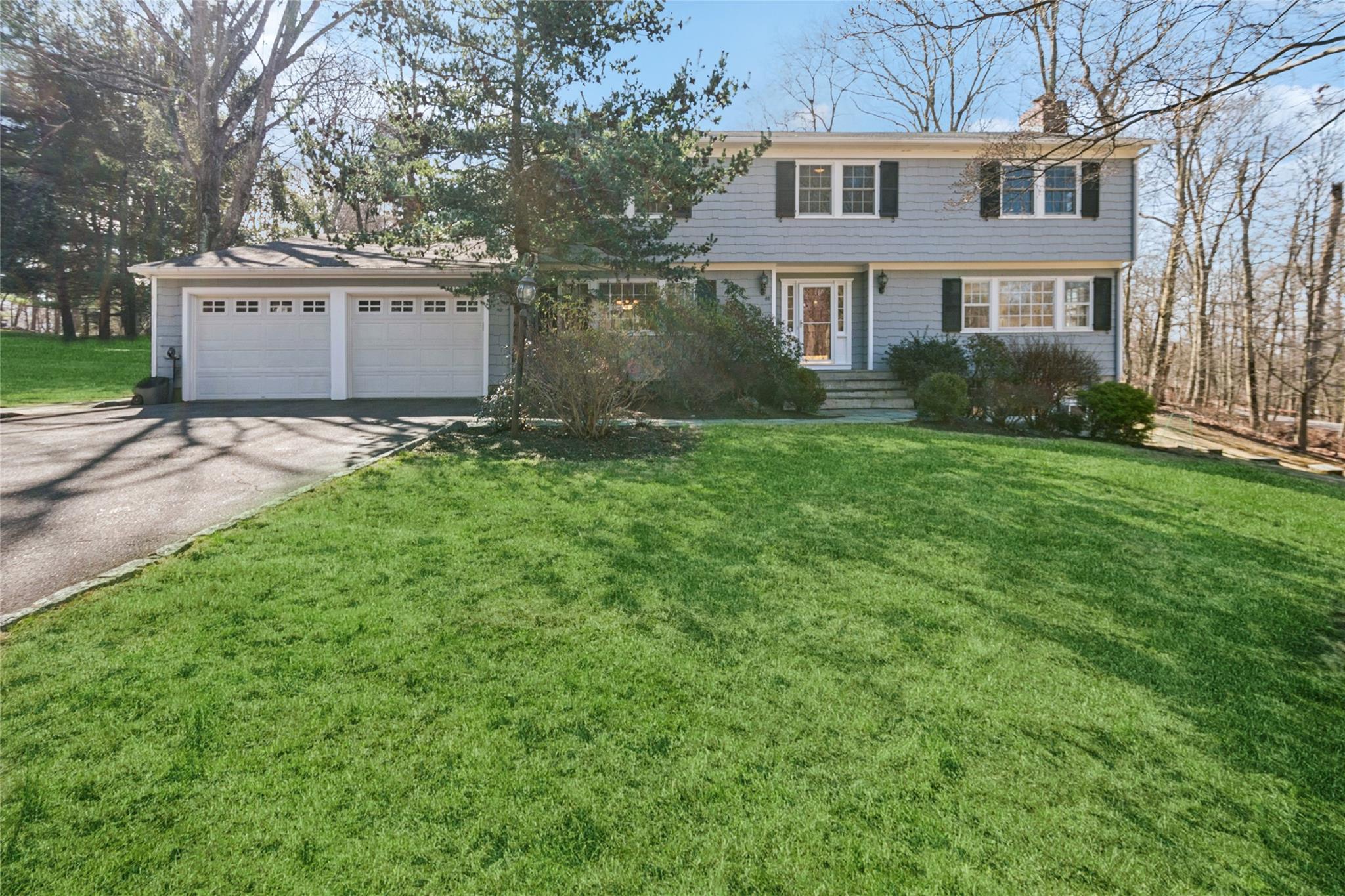 48 Central Drive Briarcliff Manor, NY 10510 - Photo 1 of 1 Colonial home featuring a front lawn, driveway, and an attached 2-car garagey