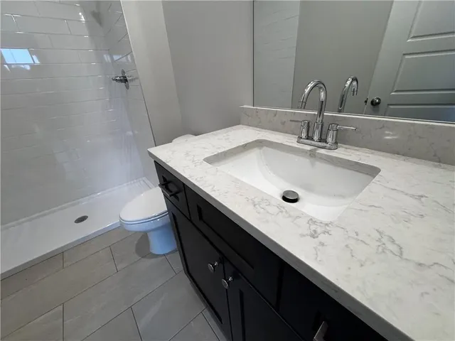 a bathroom with a granite countertop sink a mirror and shower