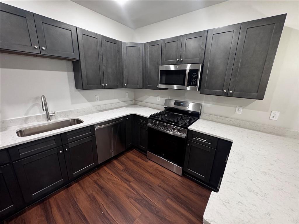 1777 Temple Avenue, Unit N Atlanta, GA 30337 - Photo 6 of 22 a kitchen with wooden cabinets and a sink