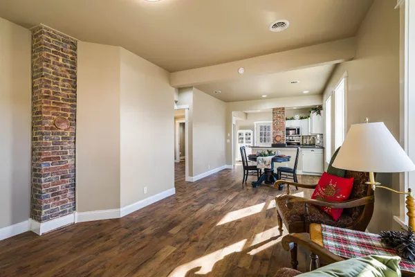 a view of a room with shelves chairs and wooden floor