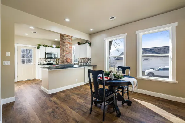 a kitchen with a table chairs refrigerator and cabinets
