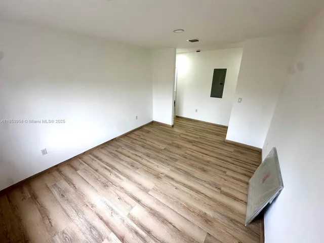 a view of a room with wooden floor