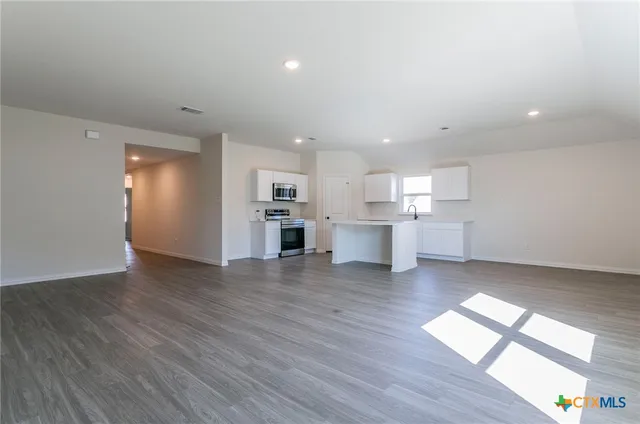a view of kitchen with wooden floor and electronic appliances