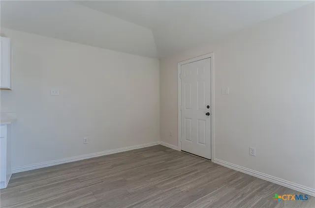 a view of an empty room with wooden floor